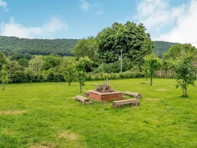 a park with benches and trees in a field at Violet Cottage in Hereford