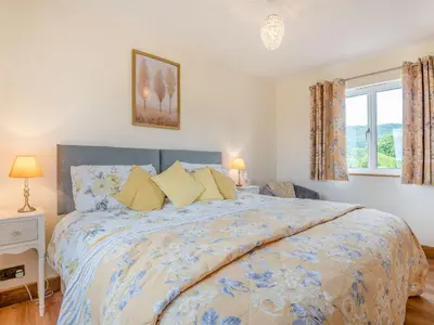a bedroom with a large bed with yellow pillows at Violet Cottage in Hereford
