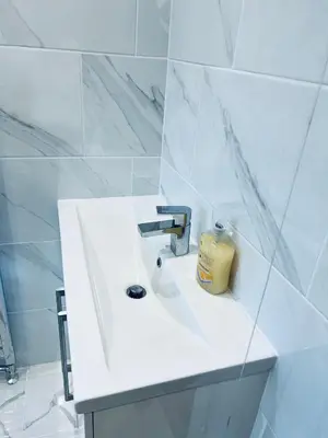 a white bathroom with a sink with a candle on it at 21 ,North Street in Shrewsbury