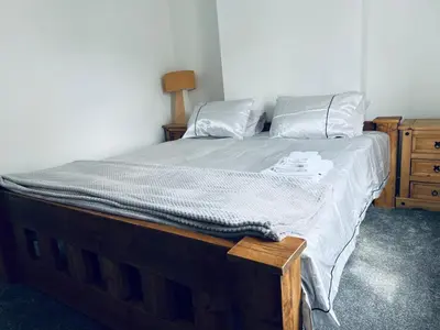 a bedroom with a bed with a wooden frame and a dresser at 21 ,North Street in Shrewsbury