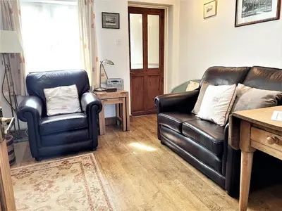 a living room with two leather chairs and a couch at Cosy cottage with views over the Shropshire hills - Pass the Keys in Ludlow