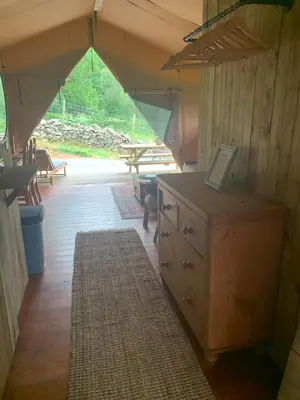 a room with a dresser and a table in a tent at Mountain View Safari Tent with Hot Tub in The Heart of Snowdonia in Dolgellau