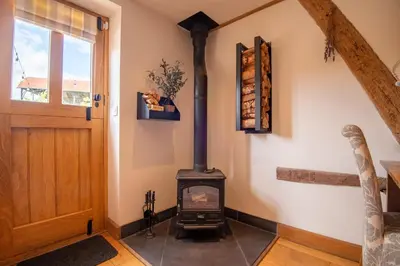 a wood stove in a room next to a door at Apple Tree Cottage - Cosy 2 Bed with Deluxe HOT TUB & Log Burner in Hereford