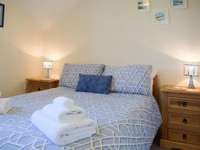 a bedroom with a bed with towels on it at Barn Cottage in Talley