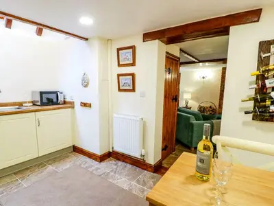 a living room with a bottle of wine on a table at Yr Hen Beudy in Tywyn