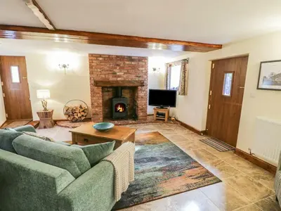 a living room with a couch and a fireplace at Yr Hen Beudy in Tywyn