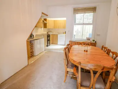 a kitchen and dining room with a wooden table and chairs at 4 Tanyrallt Terrace in Llangollen