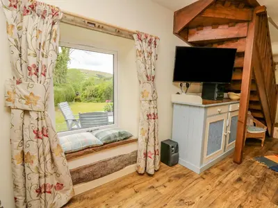 a living room with a window and a television at Buzzards Breg in Builth Wells
