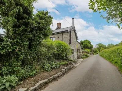 an empty road in front of a stone house at Buzzards Breg in Builth Wells