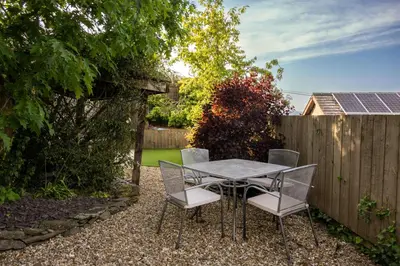a table and chairs in a backyard with a fence at Hay Barn, Penrheol Farm, Unique Barn Conversion in Builth Wells