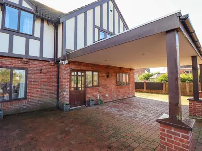 an external view of a brick house with a patio at Maesbury Manor in Oswestry