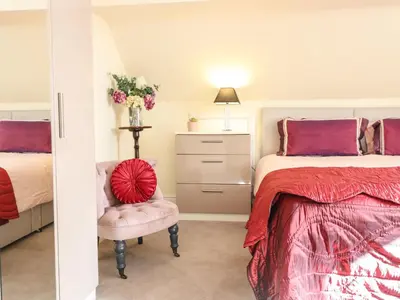 a bedroom with a bed and a chair at Maesbury Manor in Oswestry