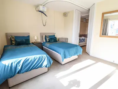 two beds in a bedroom with blue sheets at Maesbury Manor in Oswestry