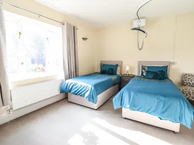 two beds in a room with a window at Maesbury Manor in Oswestry