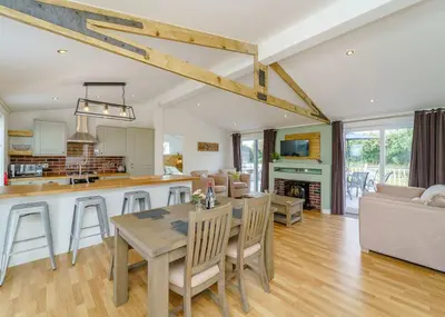 a kitchen and living room with a table and chairs at Winston Farm Lodges in Ternhill