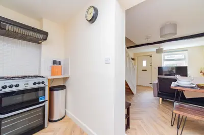 a kitchen with a stove and a dining room at Coton Hill Shrewsbury Cottage in Shrewsbury