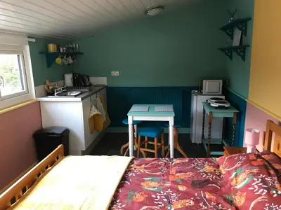 a bedroom with a bed and a kitchen with a sink at Poplar Lodge, Dee Valley Stays - cosy microlodge with detached private shower & WC in Corwen