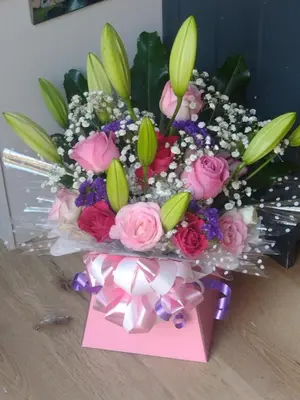a bouquet of flowers in a box with a note at Wheat Cottage - 5* Cyfie Farm with private covered hot tub in Llanfyllin