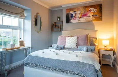 a bedroom with a large bed and a window at YR HEN FICERDY in Aberystwyth