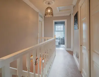a staircase in a home with a light fixture at YR HEN FICERDY in Aberystwyth