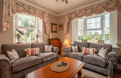 a living room with two couches and a table at YR HEN FICERDY in Aberystwyth