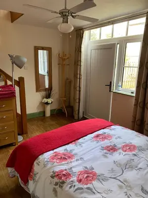 a bedroom with a bed with a red blanket on it at Stable Cottage, Bishops Castle in Bishops Castle