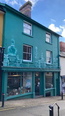 a blue building with a store in front of it at Stable Cottage, Bishops Castle in Bishops Castle