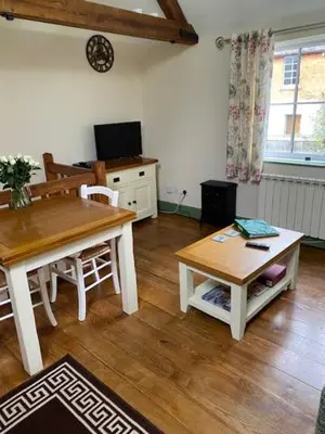 a living room with a wooden table and a dining room at Stable Cottage, Bishops Castle in Bishops Castle