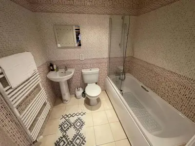 a bathroom with a sink and a toilet and a tub at Luxury 4-5 Bed Home with Games Room and Balcony in Newtown