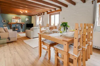 a living room with a wooden table and chairs at 3 Bed in Aberaeron oc-bow315 in Cross Inn