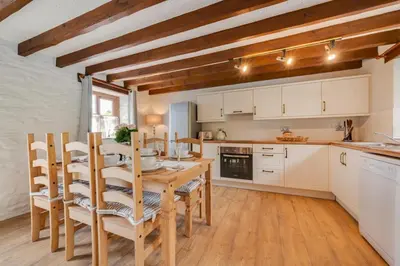 a kitchen with a table and chairs in a room at 3 Bed in Aberaeron oc-bow315 in Cross Inn