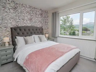 a bedroom with a large bed and a window at Lleifior in Dolgellau