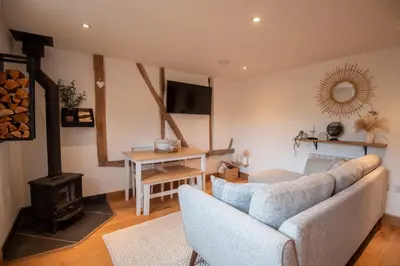 a living room with a couch and a wood stove at Bramble Cottage - Cosy 2 Bed With Deluxe HOT TUB & Log Burner in Hereford