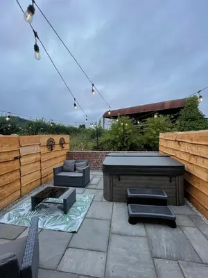 a patio with couches and a table and chairs at Bramble Cottage - Cosy 2 Bed With Deluxe HOT TUB & Log Burner in Hereford