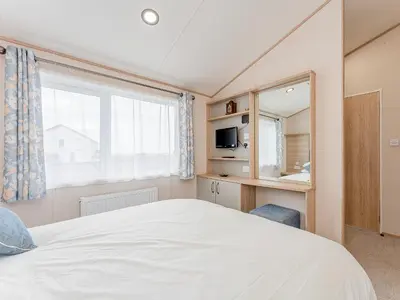 a bedroom with a large white bed and a window at Cledan in Aberaeron