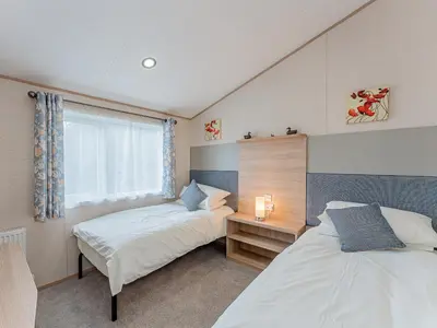 a bedroom with two beds and a window at Cledan in Aberaeron