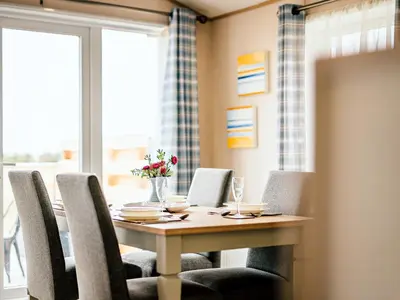 a dining room table and chairs with a table and a window at Cledan in Aberaeron