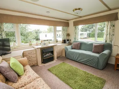 a living room with a couch and a fireplace at 8 Old Orchard in Much Wenlock