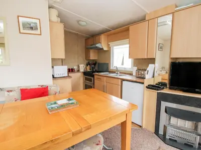 a small kitchen with a wooden table and a counter top at 3 Old Orchard in Much Wenlock