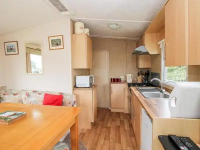 a small kitchen with a table and a counter top at 3 Old Orchard in Much Wenlock