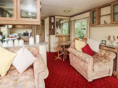 a living room with two couches and a kitchen at 2 Old Orchard in Much Wenlock