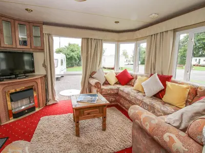 a living room with a couch and a tv at 2 Old Orchard in Much Wenlock