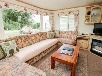 a living room with a couch and a table at 9 Old Orchard in Much Wenlock