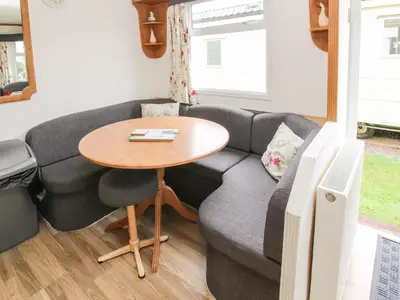a living room with a couch and a table at 5 Old Orchard in Much Wenlock