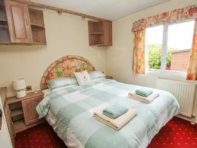 a bedroom with a large bed with towels on it at 1 Old Orchard in Much Wenlock