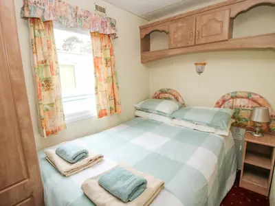 a small bedroom with a bed and a window at 1 Old Orchard in Much Wenlock