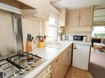 a kitchen with a stove top oven next to a sink at 7 Old Orchard in Much Wenlock
