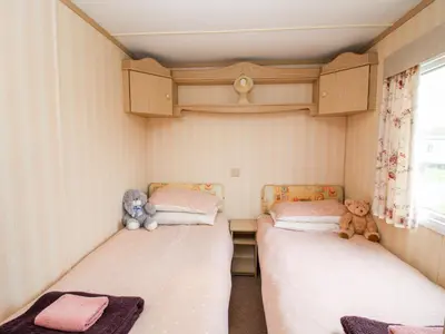 two beds in a small room with stuffed animals at 7 Old Orchard in Much Wenlock