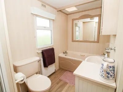 a bathroom with a toilet and a sink and a mirror at 7 Old Orchard in Much Wenlock