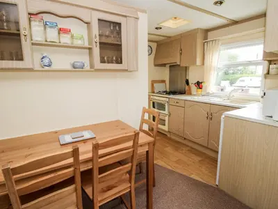 a kitchen with a wooden table and a table and chairs at 7 Old Orchard in Much Wenlock